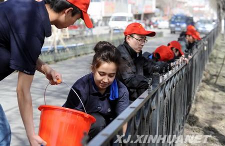 4月13日,乌鲁木齐市高新区(新市区)新科社区工作人员正在擦洗街道护栏