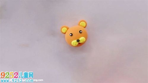 2,然后用黄色粘土做出老虎嘴部的毛发,粘上眼睛和鼻子.