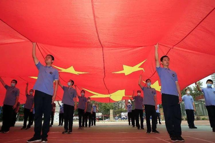 五星红旗飘起来壮观71名同学托举巨幅国旗从中国心方阵穿过
