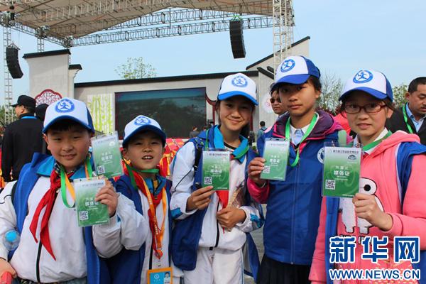 图为小记者们拿到开幕式媒体采访证