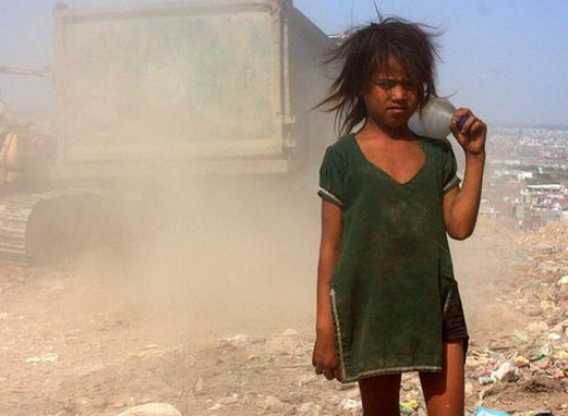 小孩头顶着一大桶水回家.她瘦弱的身子不堪重负,有着些微的弯曲