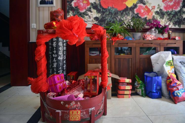 按照农村习俗,结婚头一天男方派人送红包袱,抬大食盒,把女方赔送的
