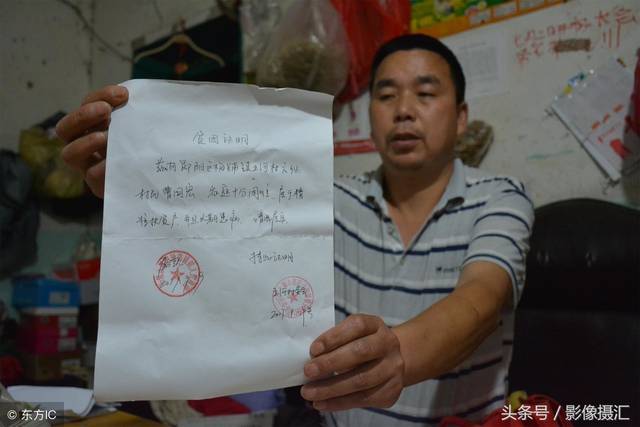 老曹在他位于十堰市郊区的租住处,展示他的贫困户证明.
