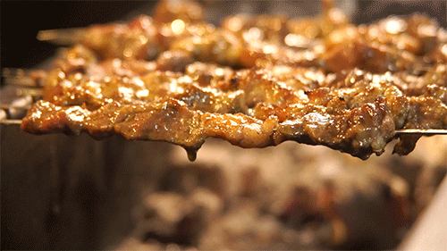 看着羊肉串不断在烤炉内翻滚,油脂像被充满气的气球般,随时迸发,而