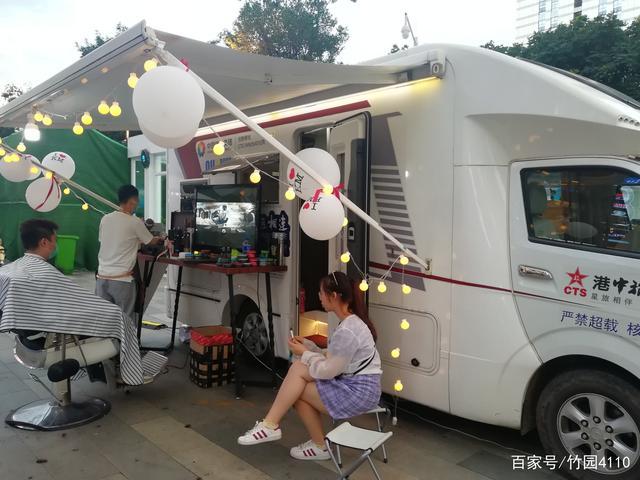 了好几辆房车,摆着摊位,放着电视,理着发,售着货,俨然一座移动的商城
