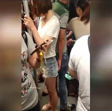 短裤女子地铁玩手机,不知身后一双手正想占便宜