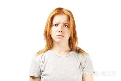 特写红发白种人年轻女子的肖像,失望的面部表情,带着皱眉的眉毛和悲惨