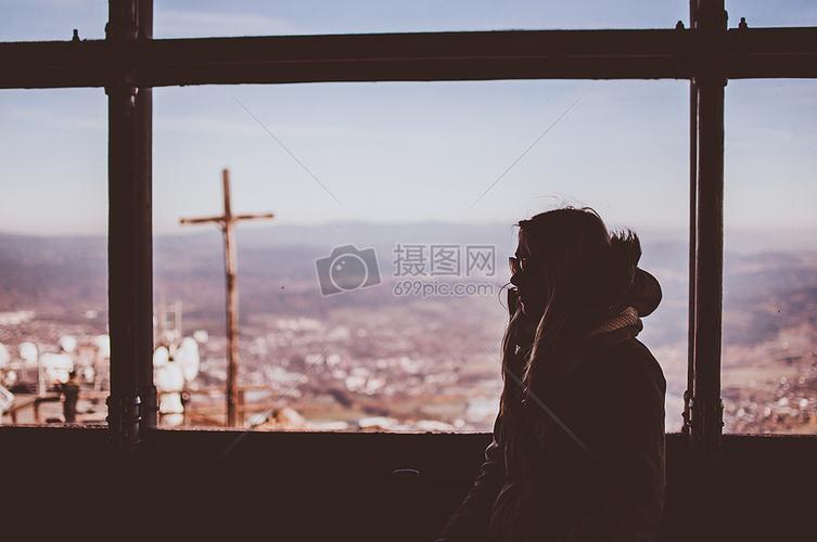 看着窗外繁荣景象的孤独女孩