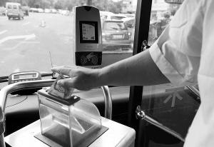 尽管公交车上设置了刷卡机,大多数乘客仍选择投币资料图