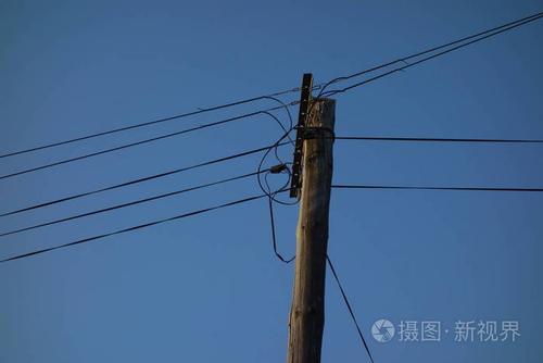 蓝天上的电线杆和电缆