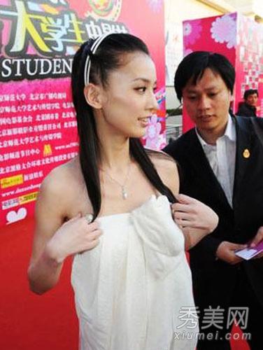 结果,因为身体太平板,撑不起抹胸裙,裙子一直往下掉,令她不得不双手拎