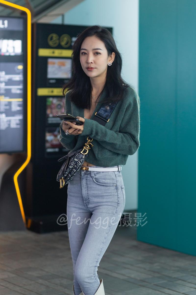 街拍:牛仔裤配白长靴,轻熟美女穿搭时尚身材棒,微微一笑很迷人