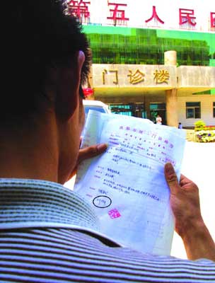 病好了的患者拿着五院开出来的诊断书非常疑惑.本报记者 詹明雷 摄