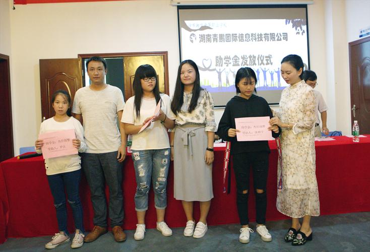 图为:青鹏国际员工代表刘莉,沈昭明,周航正在进行助学金发放仪式)