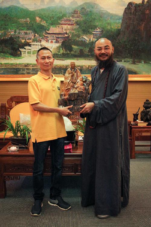 万行法师和黄志伟大师抱着《六祖》陶塑合影
