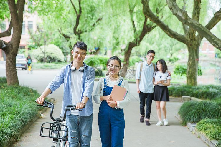 青春大学生推自行车散步聊天