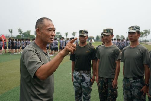 在大金山国防园训练基地,张勇(左一)对带领大学生军训的退役军人员工