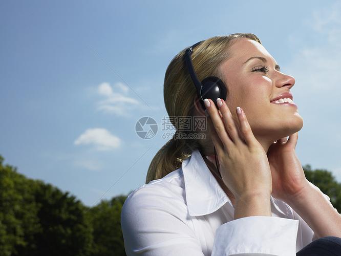 在公园里听音乐的女人