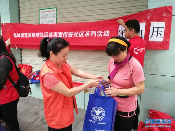 图为禁毒社工派发禁毒小礼品.中国禁毒网发