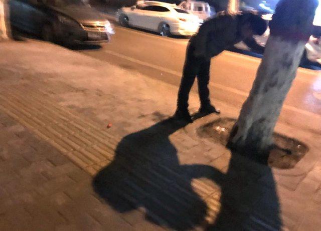 其中一位男子趴在树上呕吐不止.