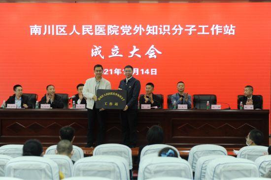 图为 南川区委常委,统战部部长毛朝银为党外知识分子工作站授牌.