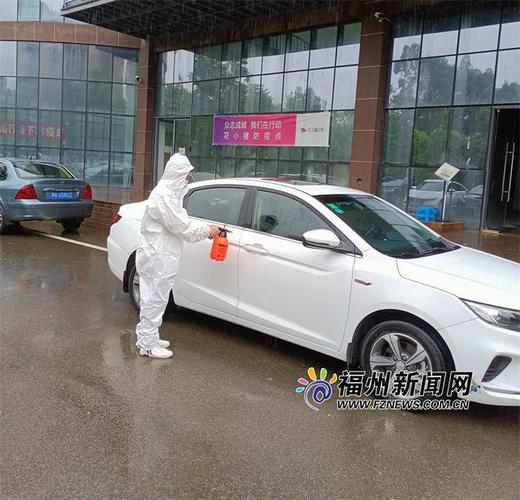 工作人员对车门把手进行消毒.