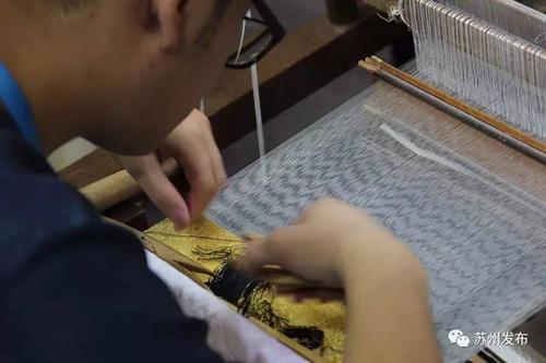 在缂丝机前,这位帅哥正在用自己的双手织就有着1500年历史的文化遗产.