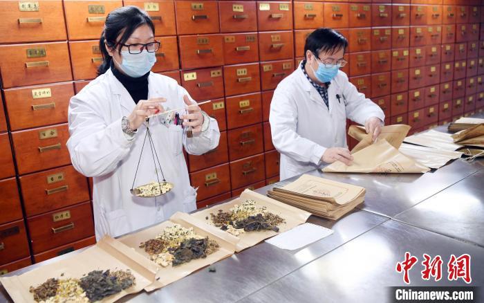 福州市中医院药剂师在医院中药房根据处方配置防疫中药.