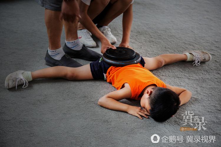 吴桥杂技萌娃:杠铃铁盘压身含泪坚持