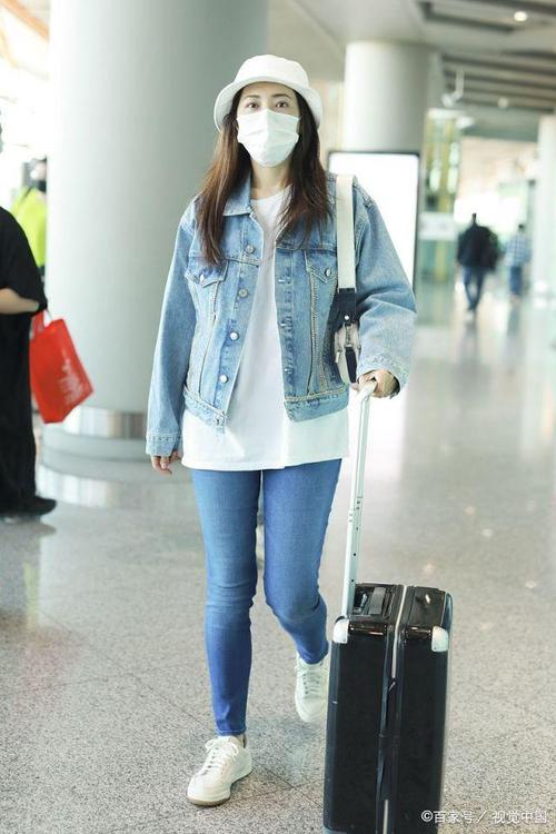 曾黎戴着口罩,拖着大行李箱,缓慢走出机场.
