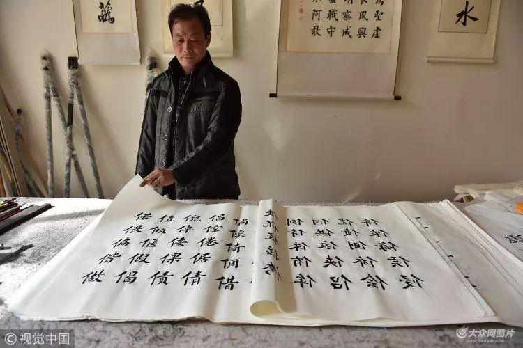 2018年4月8日,在山东省日照市莒县文街二楼,仕金正(右)在展示他