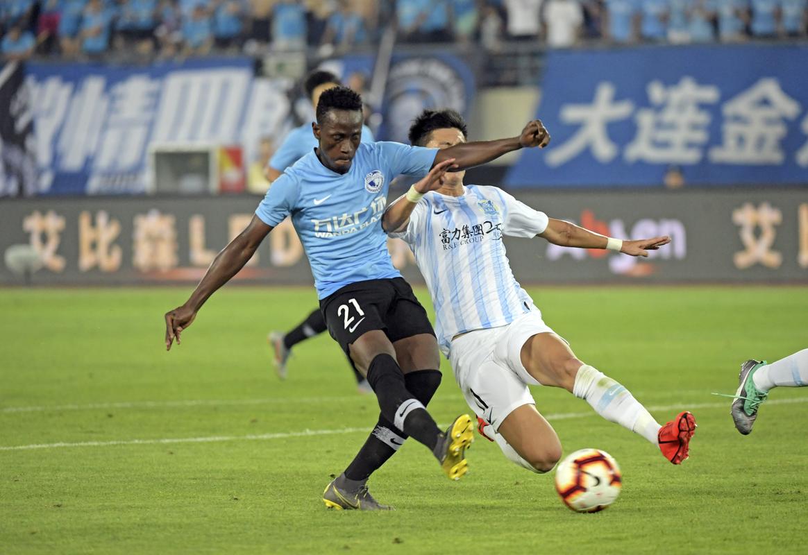 7月12日,大连一方队球员博阿滕(左)在比赛中射门.