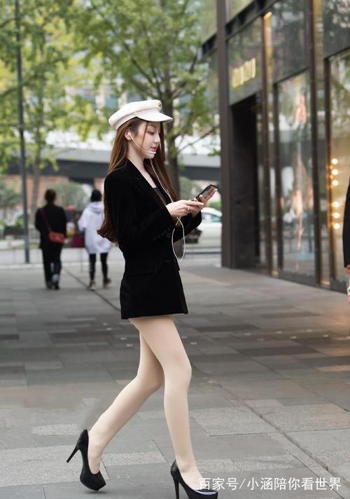 图一美女,身穿黑色长款上衣,搭配肉色丝袜,黑色高跟鞋,走在街上,回头