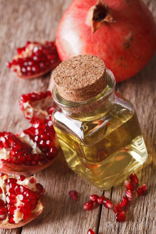 新鲜的石榴籽油在玻璃瓶宏.垂直