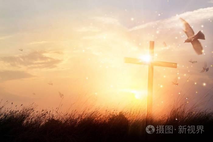 剪影基督徒十字架在草在日出背景以奇迹明亮的照明,宗教和崇拜概念