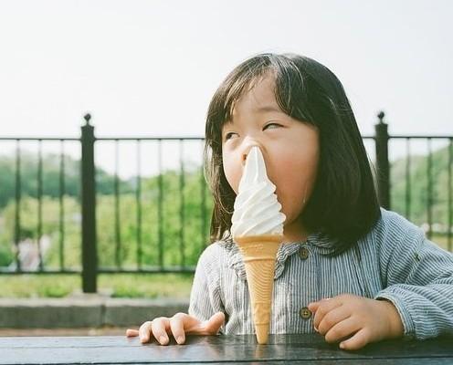 一个小女孩用冰淇淋戳鼻子的图片