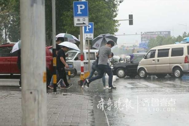 烟台今晨突降急雨 路上行人在雨中穿梭