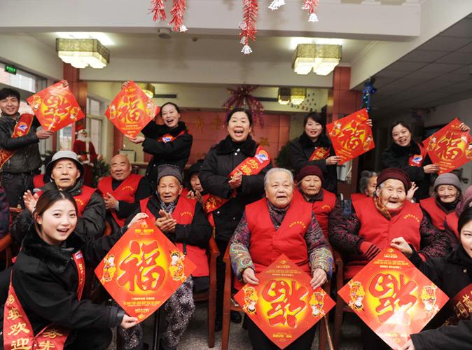 邹侠(中)和服务班成员给敬老院老人送祝福,迎新年.
