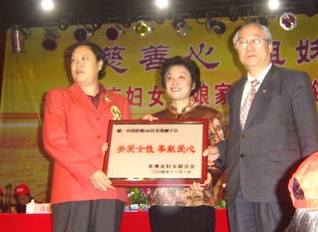市妇联主席胡利群向国际狮子总会中国深圳380区东海分会赠送牌匾