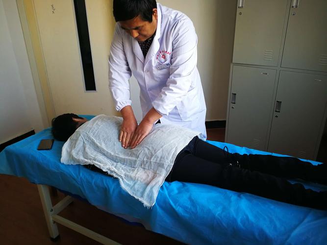 圈发俊推拿治疗师正在治疗腰椎间盘突出症患者