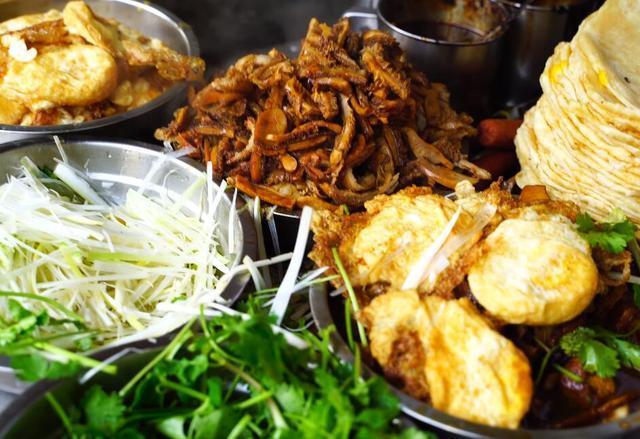 老阿姨做卷饼,一张饼卷很多种配菜,每天早晨卷完100张