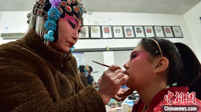 图为哈哈腔剧团化妆间,老艺人为小演员化妆. 尹向平 摄