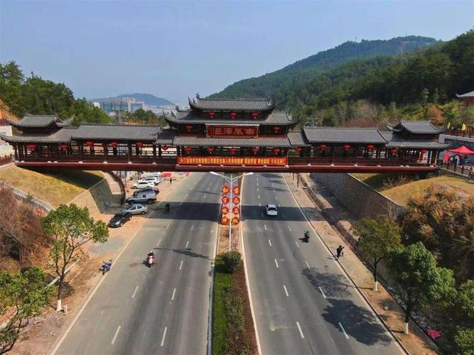 名城入口的南屏山和马兰山之间,一座古色古香的大型仿古廊桥跨越大道