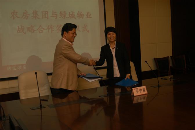 图为农房集团董事长闻淼(左),绿城物业董事长兼总经理李海荣在签约