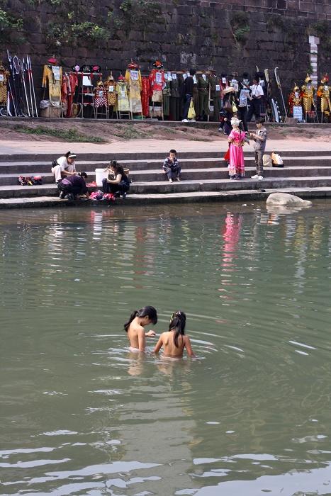 两个小女孩光着身子在沱江中嬉戏,对于她们来说,这沱江就是孩时最大的