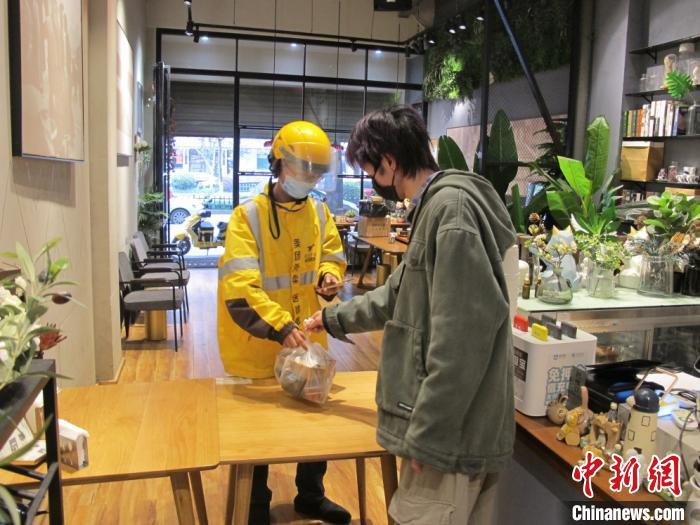 图为:外卖员从"taipei"咖啡店取餐 张声雷 摄