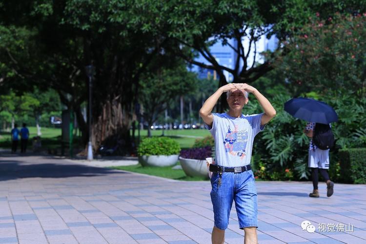 6月11日,市民手搭凉棚走过季华园.佛山日报摄影俱乐部徐懿君摄