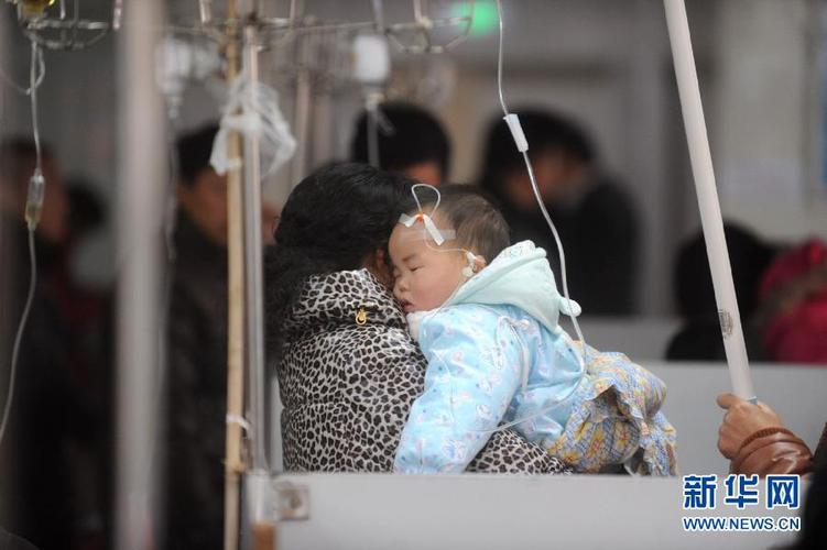 2月8日,在江苏扬州第一人民医院的输液室,一名患儿依偎在母亲怀里