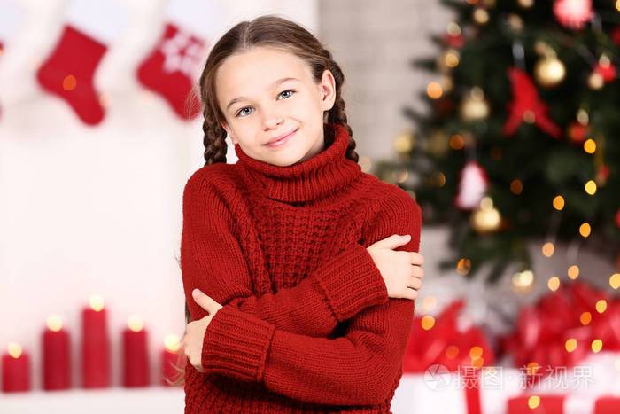 家附近圣诞树旁穿红毛衣的年轻女孩