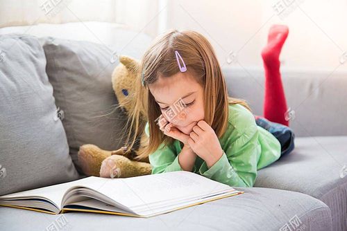 在沙发上趴着看书的小女孩图片
